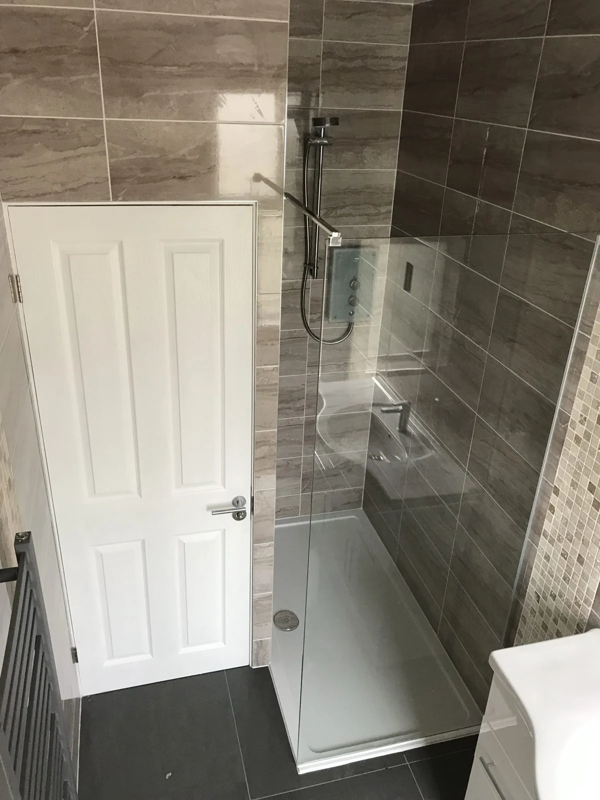 Shower room with stone-effect tiles and glass screen