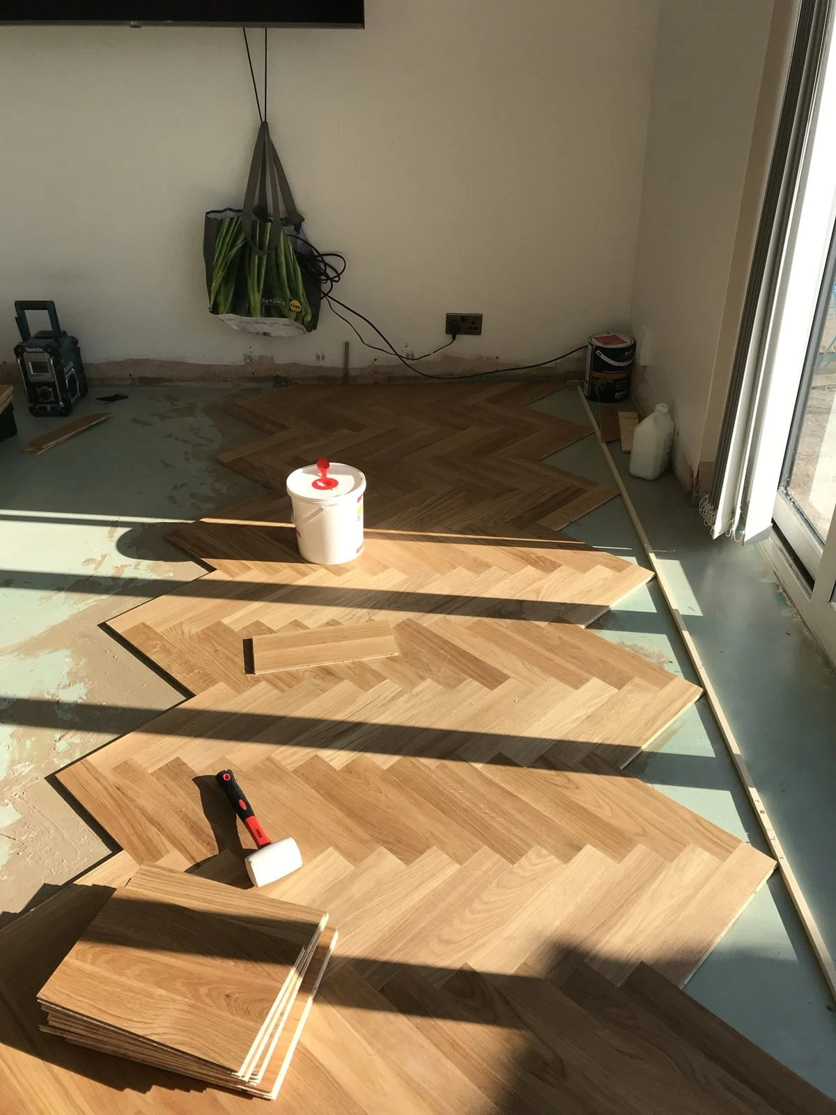 Oak herringbone blocks being fitted row by row in Bristol