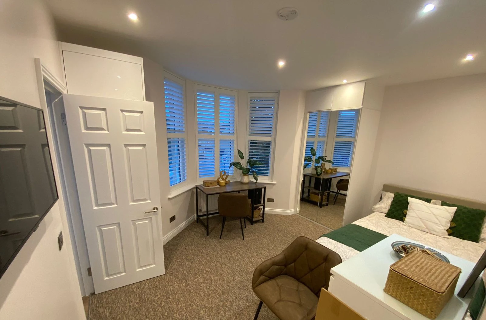Bedroom with bay window, shutters and mirrored wardrobe in Bath