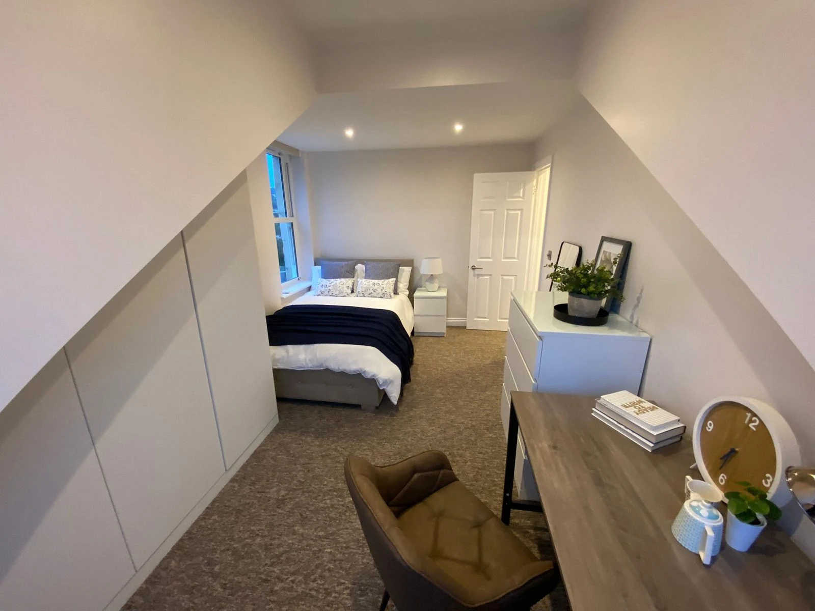 Loft bedroom with built-in eaves storage and desk in Bath