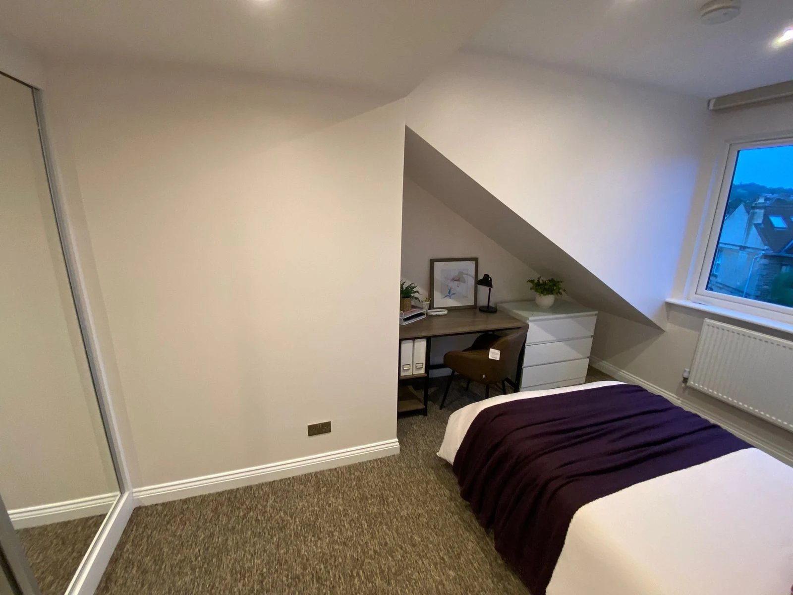 Loft bedroom with desk tucked under the sloped ceiling in Bath