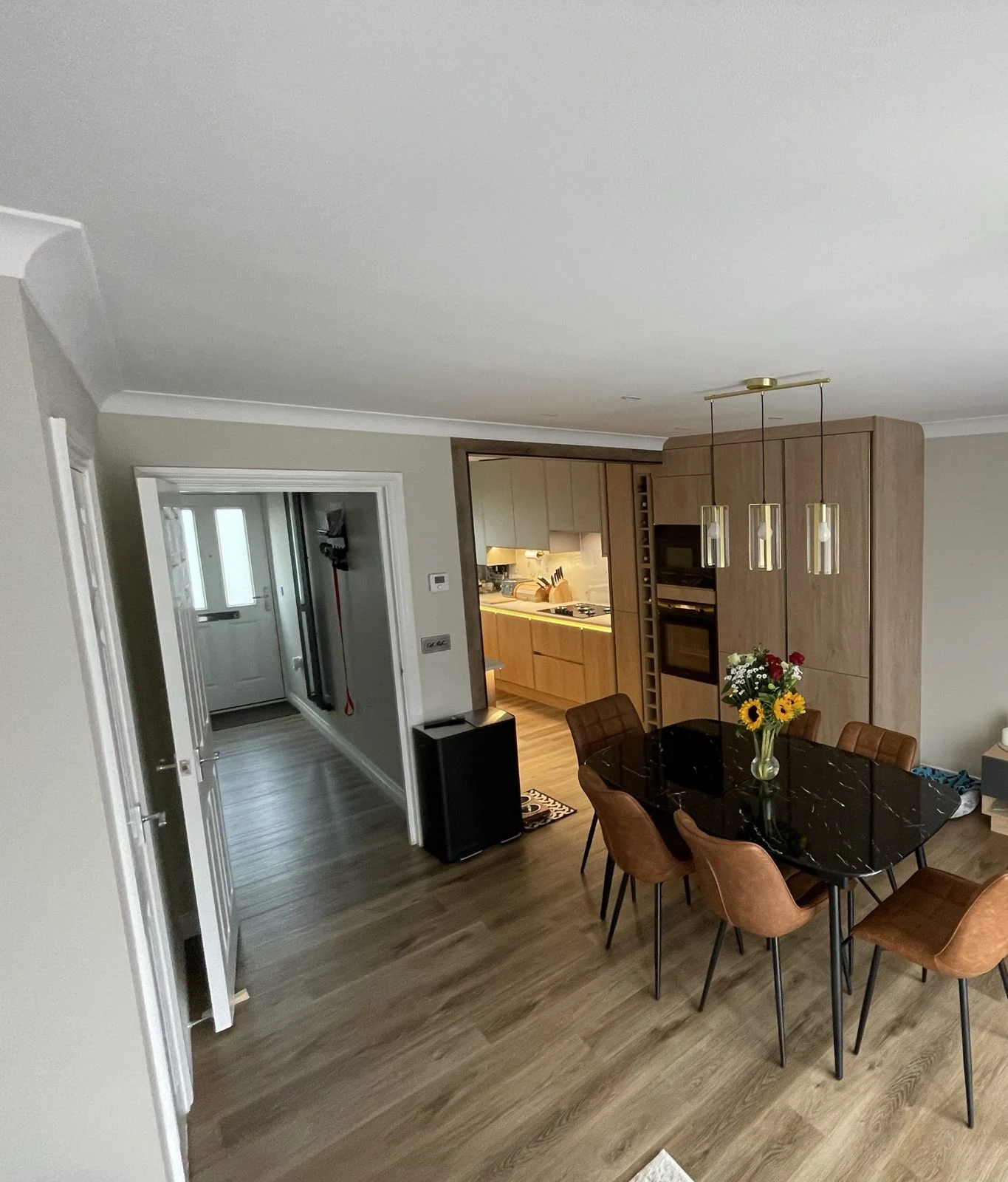 Open-plan dining room with a view into the new oak-effect kitchen