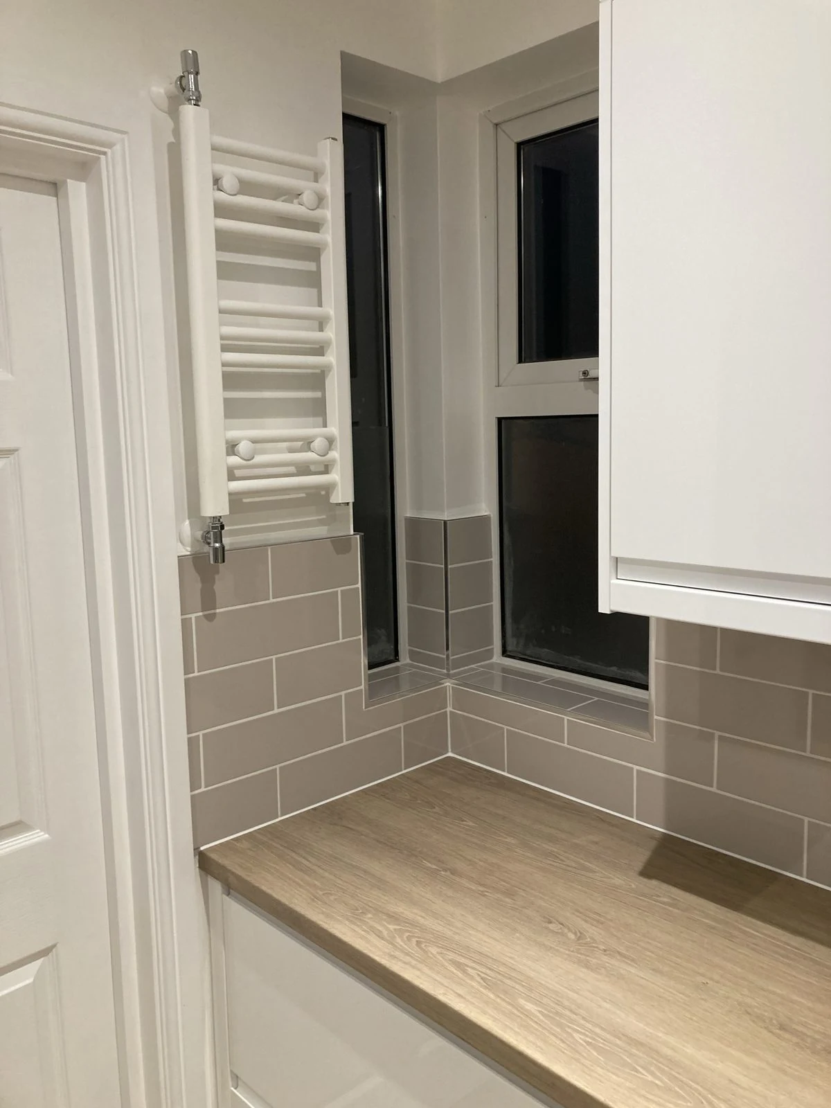 Neat metro tiling wrapped around a kitchen window reveal