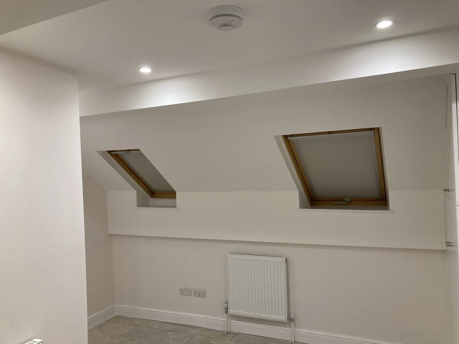 Loft room with two roof windows and radiator
