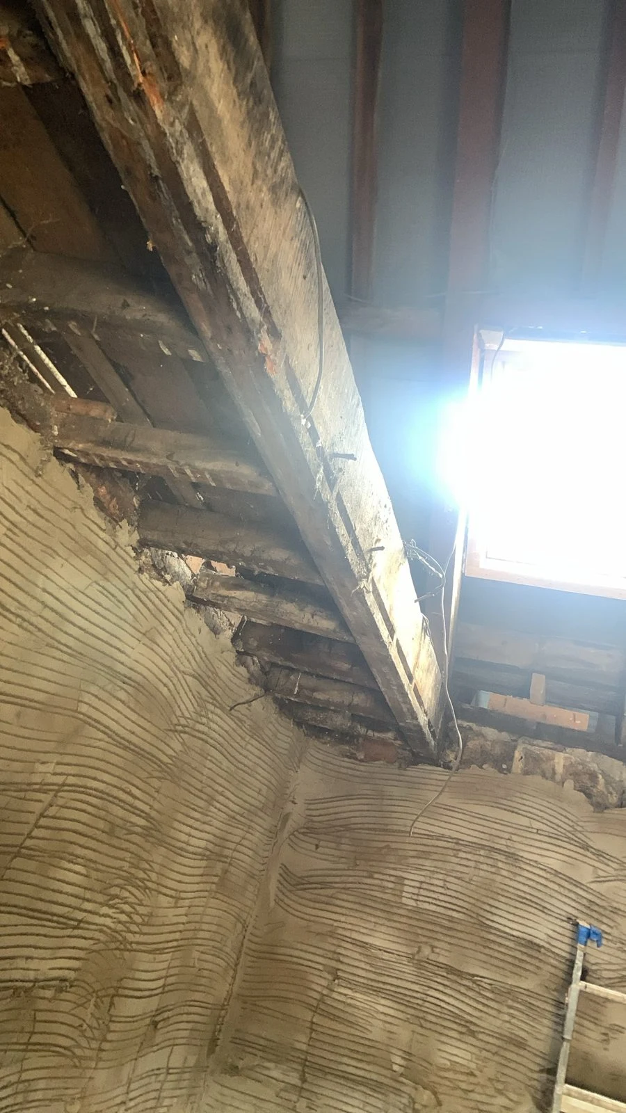 Loft before renovation with original timber beam and old plaster